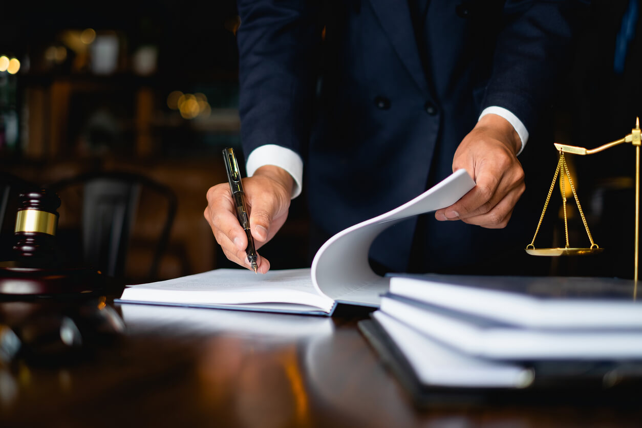 Close up lawyer businessman working or reading lawbook in office workplace for consultant lawyer concept.Employers Wrestling with Fiduciary Benefits Compliance Issues, Leave Laws