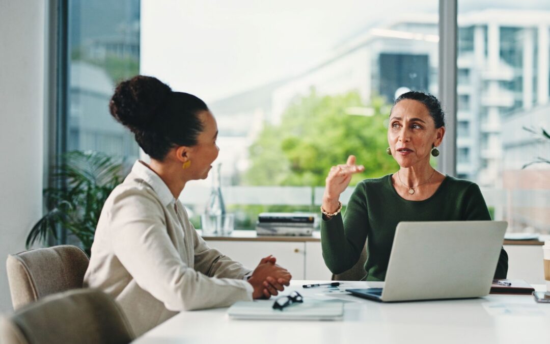 An HR professional meeting one-on-one with an employee to review benefits enrollment options.