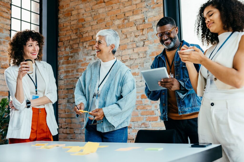 A diverse group of employees across different generations collaborating in an office setting.